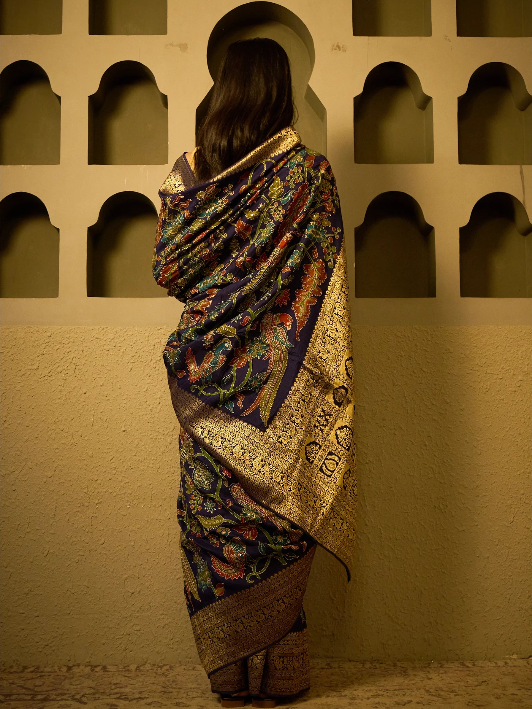 text Detailed close-up of Aari embroidery and Kalamkari motifs on navy blue soft silk saree